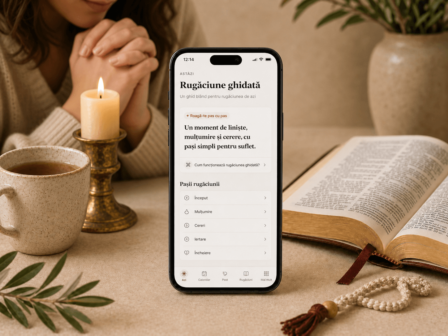 Telefon cu funcția de rugăciune de suflet, lângă o lumânare aprinsă, Biblie deschisă și metanier.